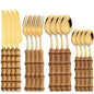 Set di posate da 16 pezzi in acciaio inossidabile con manico in bambù naturale, include forchette, cucchiai, coltelli e stoviglie.