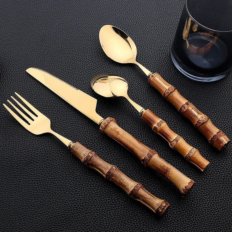 Set di posate da 16 pezzi in acciaio inossidabile con manico in bambù naturale, include forchette, cucchiai, coltelli e stoviglie.