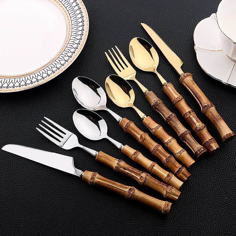 Set di posate da 16 pezzi in acciaio inossidabile con manico in bambù naturale, include forchette, cucchiai, coltelli e stoviglie.