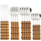 Set di posate da 16 pezzi in acciaio inossidabile con manico in bambù naturale, include forchette, cucchiai, coltelli e stoviglie.