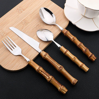Set di posate da 16 pezzi in acciaio inossidabile con manico in bambù naturale, include forchette, cucchiai, coltelli e stoviglie.