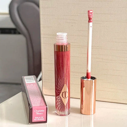 Charlotte, lucidalabbra al gusto di frutta, blush in polvere colorata, stick, tubetto rosa e oro, rossetto facile da applicare, Tilbury Cosmetics.