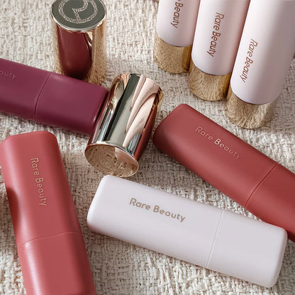 Balsamo per labbra multicolore in stick, blush liquido in polvere, linea di cosmetici Rare Beauty, Believe Happy Bliss, a lunga tenuta, facile da applicare, per un trucco impeccabile.