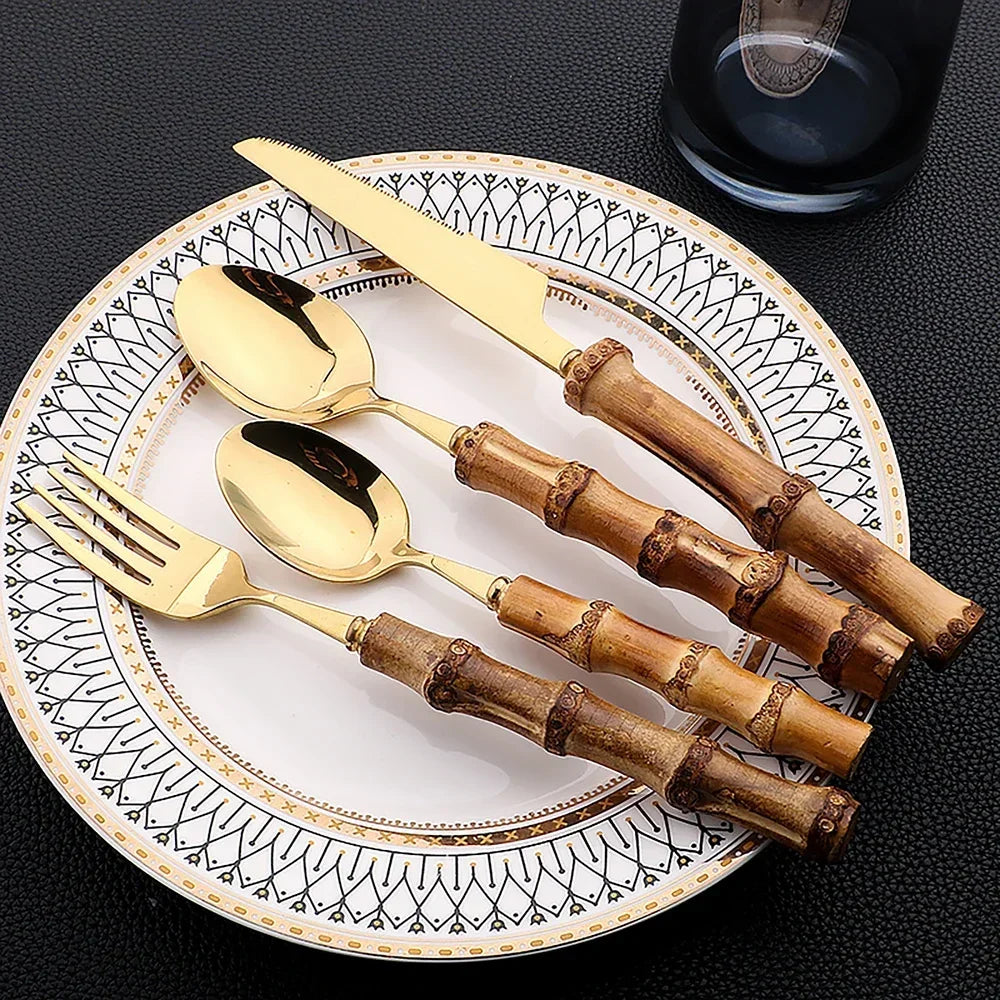 Set di posate da 16 pezzi in acciaio inossidabile con manico in bambù naturale, include forchette, cucchiai, coltelli e stoviglie.